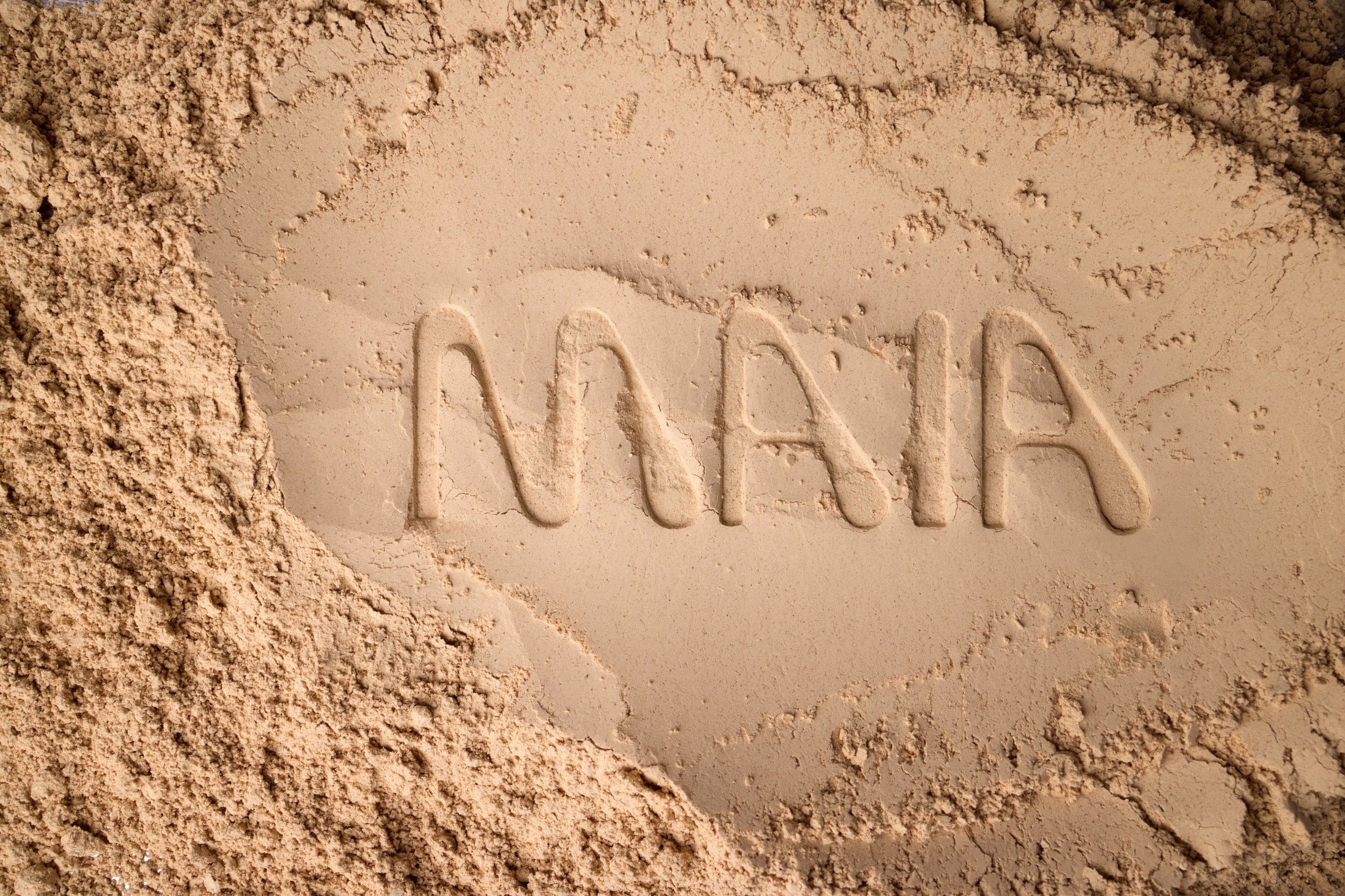 The word "MAIA" written in fine mycelium flour, symbolizing Maia Farms’ fungi-based innovation and connection to nature, nutrition, and storytelling.