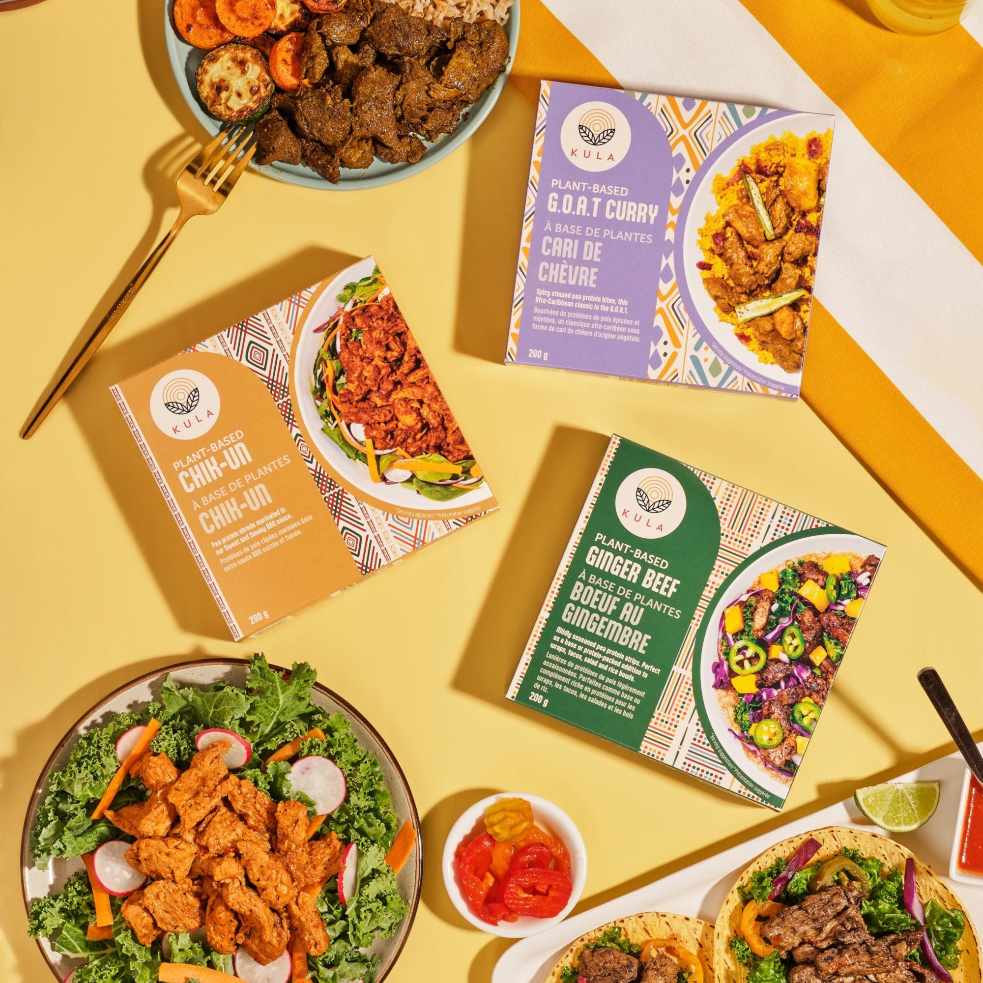 Flat lay of Kula Foods plant-based meals featuring G.O.A.T Curry, Ginger Beef, and Chik-Un, surrounded by vibrant prepared dishes—ready-to-eat vegan meals powered by mushrooms and bold global flavours